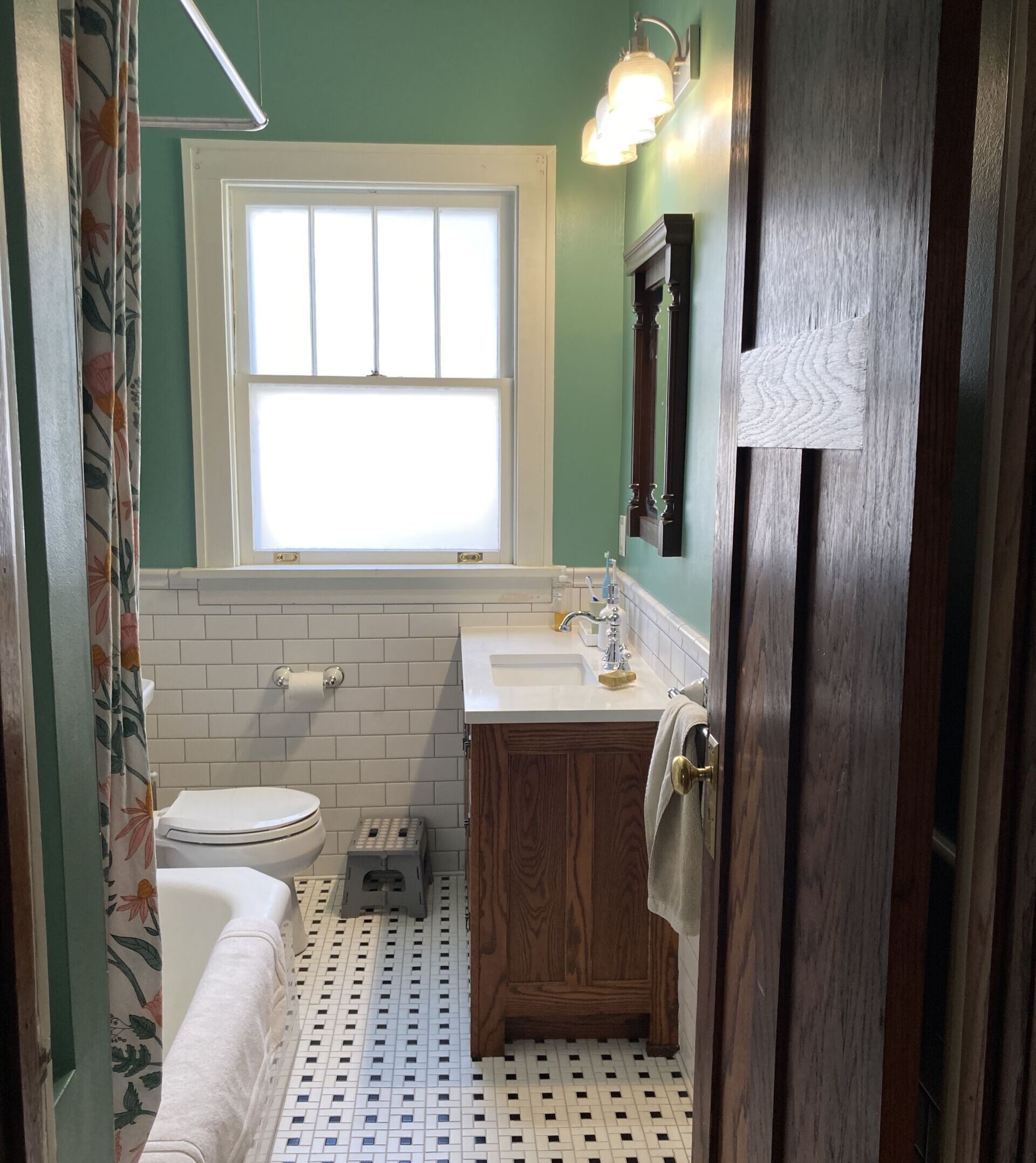 Updated bathroom with new white tile and fresh green paint