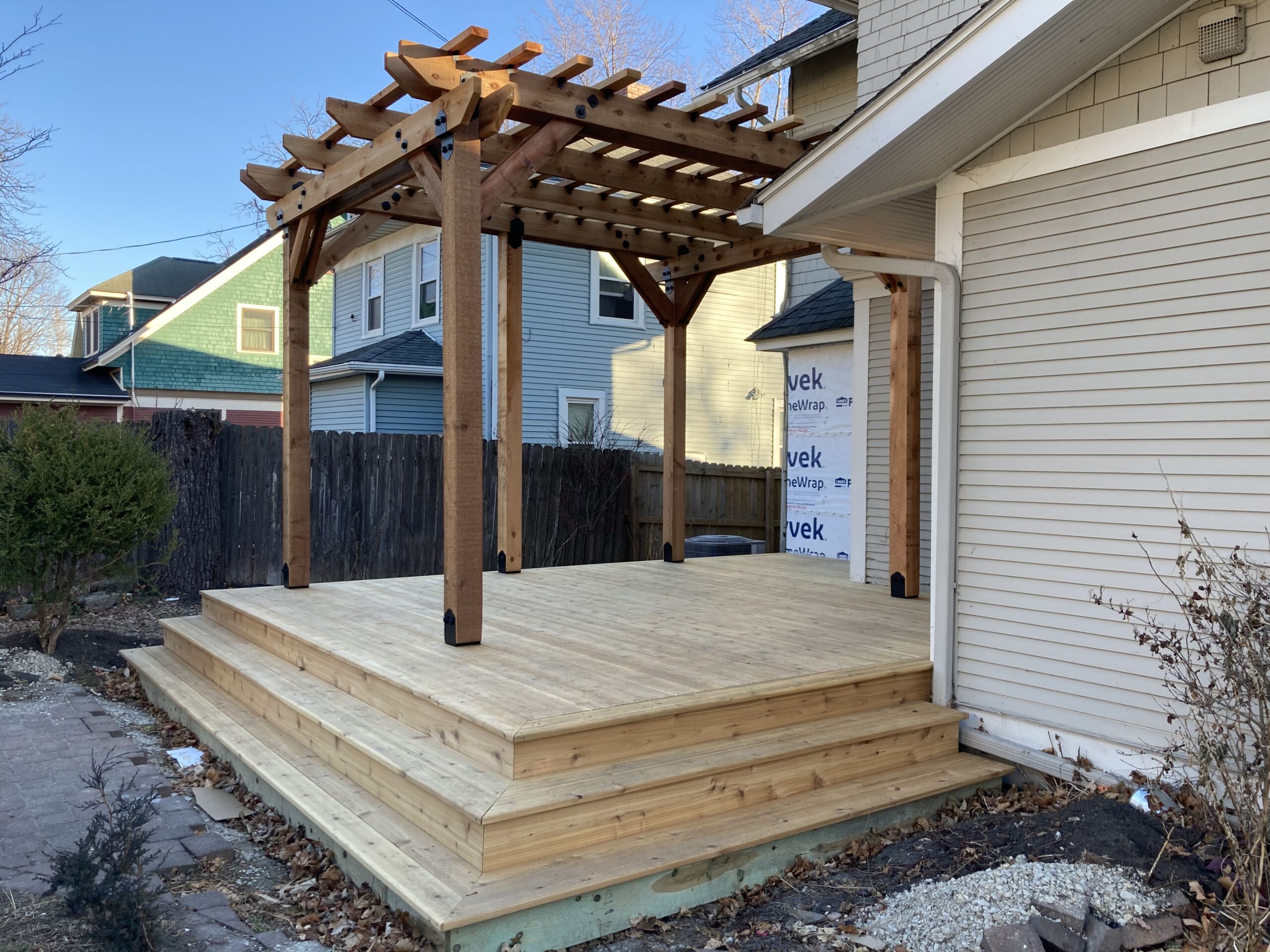 New wooden pergola and deck in backyard of home