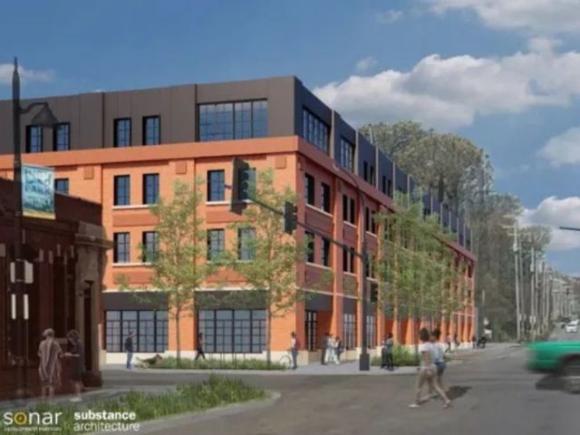 Picture of building rendering, red brick with black top floor, trees lining the street